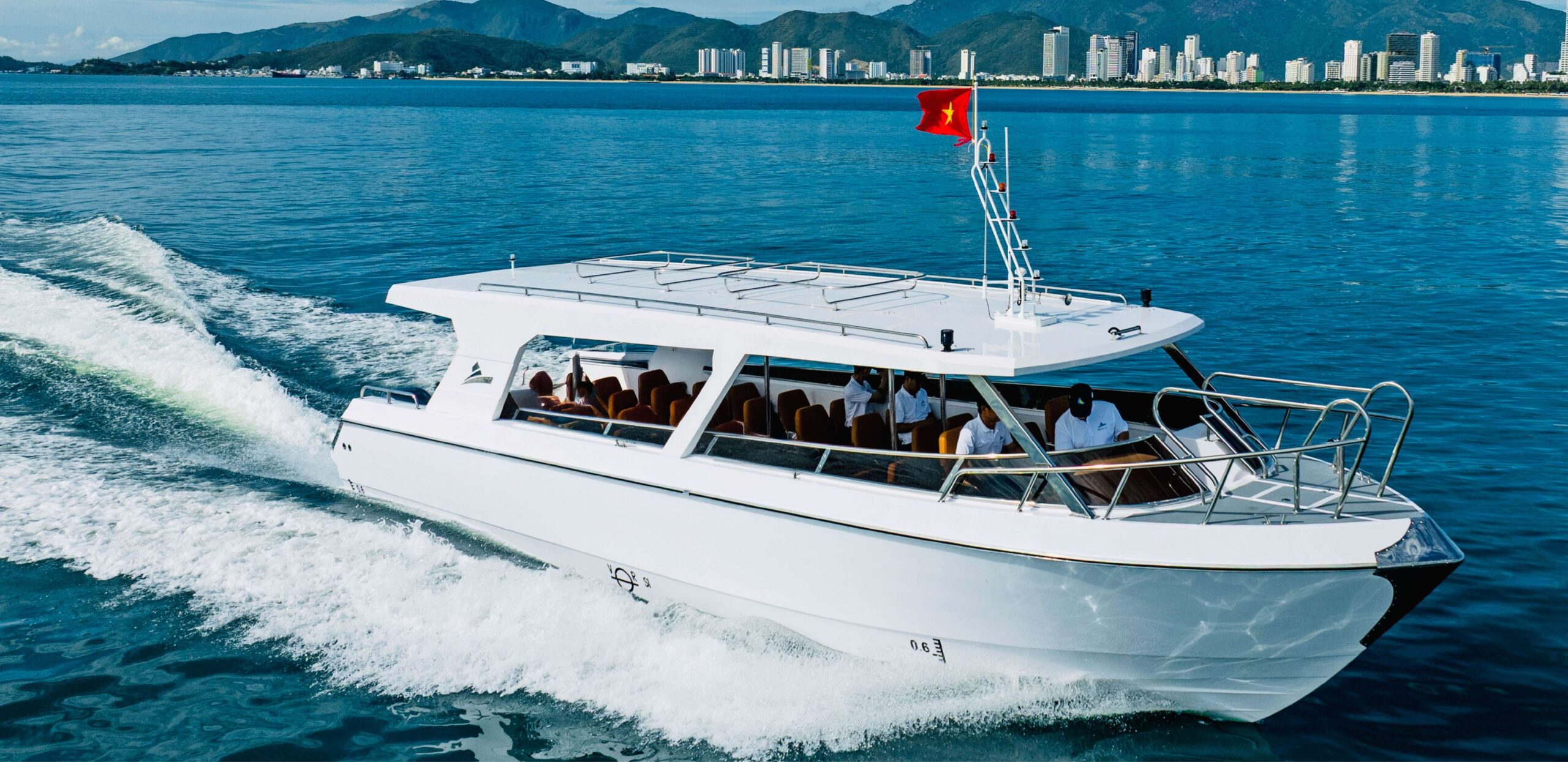Tàu khách C12 Song Lo Boat vận hành gần thành phố biển, phù hợp du lịch và vận tải hành khách. C12 passenger boat by Song Lo Boat operating near seaside city, suitable for tourism and transport.
