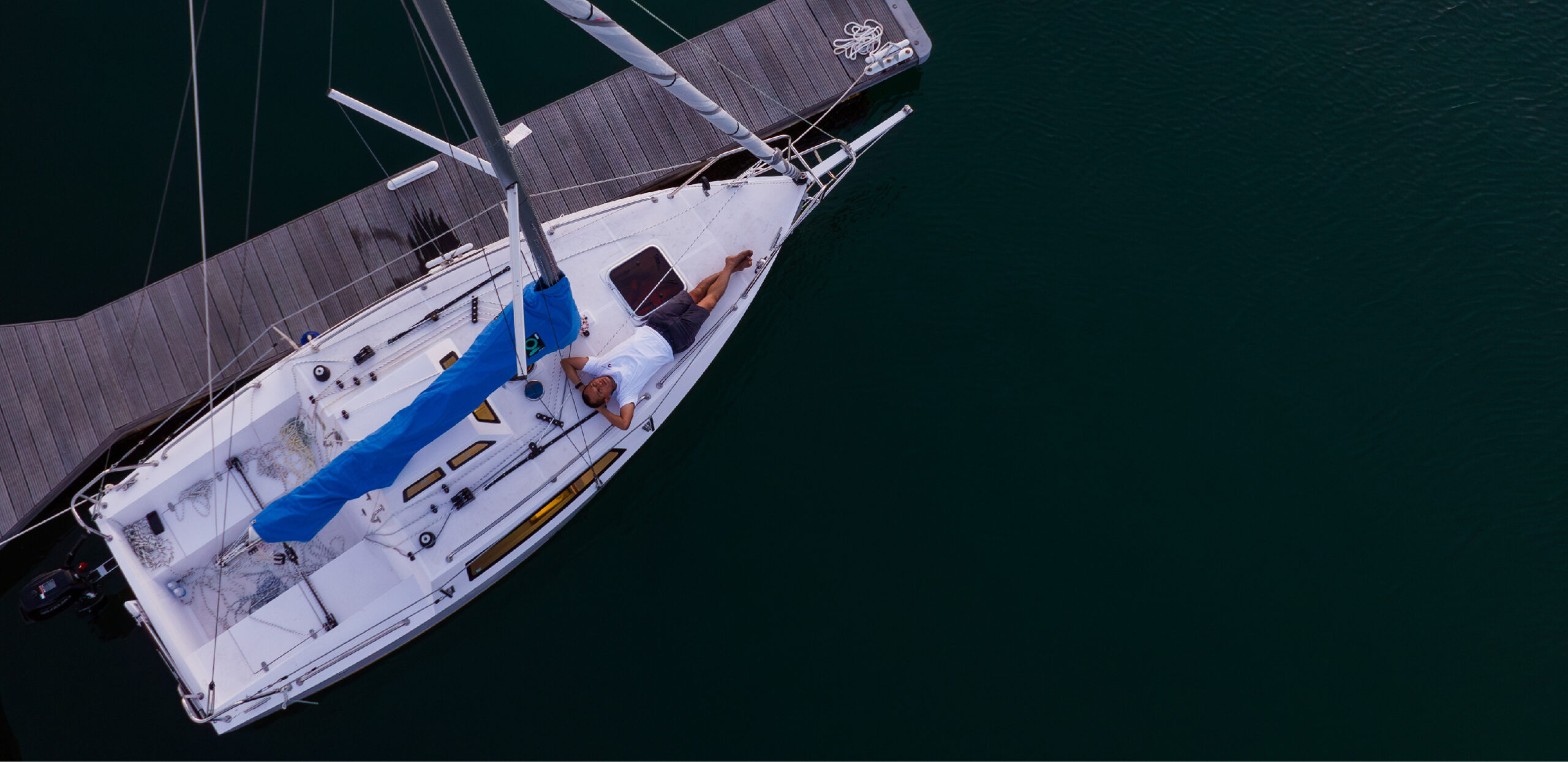 Thuyền buồm Seanata 580 góc chụp trên không, cánh buồm xanh nổi bật – Aerial shot of Seanata 580 with striking blue sail